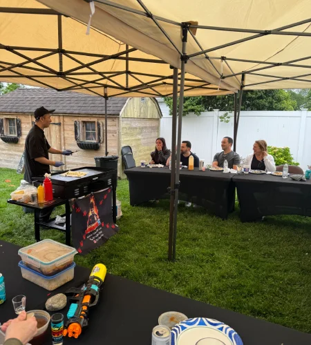 Small group enjoying an at-home hibachi dinner in a backyard setting in Baltimore