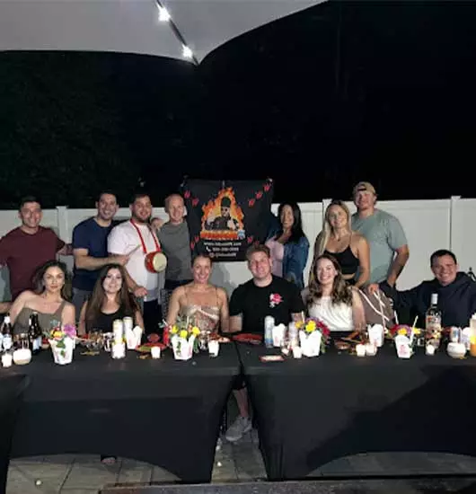 Guests with private hibachi chef at night backyard hibachi at an Airbnb vacation rental in Tampa