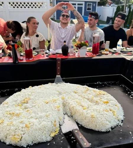 Guests enjoying hibachi fried rice prepared by a private chef during backyard dinner