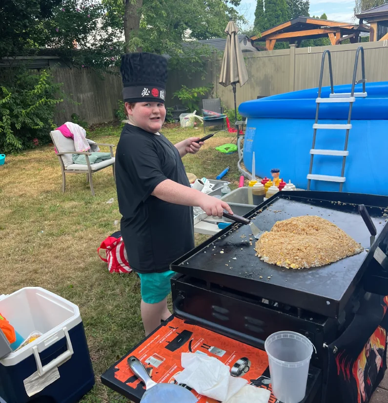 Private hibachi chef grilling teppanyaki in a backyard at home