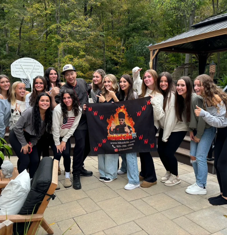 Guests posing for a group photo after hibachi-at-home dinner